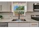 Close-up of the kitchen sink area showing granite countertop, modern faucet, and white cabinets at 1726 25Th S Ave, St Petersburg, FL 33712