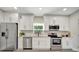Well-lit kitchen featuring stainless steel appliances, white cabinets, and granite countertops at 1726 25Th S Ave, St Petersburg, FL 33712