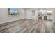 Bright living room with gray wood flooring, lots of natural light, and a view into the kitchen at 1726 25Th S Ave, St Petersburg, FL 33712