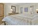 Cozy bedroom showcases a large bed, dresser with mirror, and doorway leading to an adjacent bathroom at 18650 Gulf Blvd # 303, Indian Shores, FL 33785