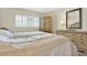 Inviting bedroom featuring a wooden bed, dresser with mirror, and natural light streaming through the window at 18650 Gulf Blvd # 303, Indian Shores, FL 33785