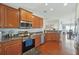 The kitchen has stainless steel appliances, wooden cabinets and dark countertops with open concept design at 20224 Natures Spirit Dr, Tampa, FL 33647