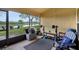 Enclosed patio featuring workout area and scenic views of the backyard and lake, with ample natural light streaming through at 20224 Natures Spirit Dr, Tampa, FL 33647