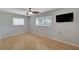 Cozy bedroom with laminate wood floors, a ceiling fan, and a mounted television at 2127 Scotland Dr, Clearwater, FL 33763
