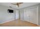 Bedroom featuring laminate wood floors, a ceiling fan, a closet with folding doors, and a television at 2127 Scotland Dr, Clearwater, FL 33763
