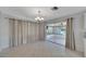 Bright living room with tile flooring, large sliding glass doors to the sun room, and a modern light fixture at 2127 Scotland Dr, Clearwater, FL 33763
