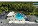 Aerial view of the community pool, with lounge chairs, lush landscaping, and shade trees at 2127 Scotland Dr, Clearwater, FL 33763