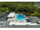 Aerial view of the community pool, with lounge chairs, lush landscaping, and shade trees at 2127 Scotland Dr, Clearwater, FL 33763