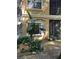 Exterior view of the building with lush landscaping, mature trees, and exterior stone details at 2220 Chianti Pl # 8-0817, Palm Harbor, FL 34683