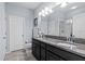 Elegant bathroom with double granite vanity, large mirror, modern lighting, and tiled floors at 2221 Broadway View Ave, Brandon, FL 33510