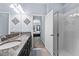 Modern bathroom with double vanity, granite countertop, shower with glass door, and tiled floors at 2221 Broadway View Ave, Brandon, FL 33510