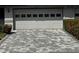 Stylish gray-and-white stone driveway leading to a two-car garage of a well-maintained house at 2411 Lancaster Dr, Sun City Center, FL 33573