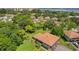 An aerial view displaying the home's roof, surrounding community, lush greenery, and water in the distance at 2934 Lichen Ln # A, Clearwater, FL 33760