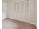 View of a simple bedroom with neutral walls, carpet, closet doors, and a white door at 2934 Lichen Ln # A, Clearwater, FL 33760