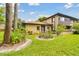 Exterior view featuring a charming two-story home with a well-manicured lawn, mature trees, and lovely landscaping at 2934 Lichen Ln # A, Clearwater, FL 33760