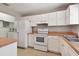 Functional kitchen featuring white appliances, matching cabinets, and convenient access to the laundry area at 2934 Lichen Ln # A, Clearwater, FL 33760