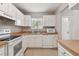 Efficient kitchen with white cabinets, matching appliances, tile floors, and a double stainless steel sink at 2934 Lichen Ln # A, Clearwater, FL 33760