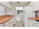 Efficient kitchen layout with white cabinets, appliances, and access to the laundry area for added convenience at 2934 Lichen Ln # A, Clearwater, FL 33760