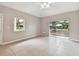 Bright living room featuring neutral walls, tile floors, a sliding glass door, and a window at 2934 Lichen Ln # A, Clearwater, FL 33760