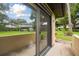 A view of the lawn and shade trees from the patio with sliding glass doors into the house at 2934 Lichen Ln # A, Clearwater, FL 33760