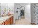 Bathroom with neutral tile, vanity, and walk-in closet with shelving for storage at 30475 Satinleaf Run, Brooksville, FL 34602