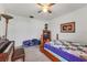 Bedroom features ceiling fan, carpet, piano, and window letting in natural light at 30475 Satinleaf Run, Brooksville, FL 34602