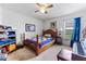 Bright bedroom with ceiling fan, a piano, and window with view to the outdoors at 30475 Satinleaf Run, Brooksville, FL 34602