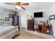Cozy bedroom features a ceiling fan, TV, dresser, and carpeted floors at 30475 Satinleaf Run, Brooksville, FL 34602