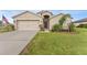 Charming single-story home with a well-manicured lawn, two car garage, and welcoming front entrance at 30475 Satinleaf Run, Brooksville, FL 34602