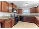 Traditional-style kitchen features wood cabinets, granite countertops, and black appliances at 30475 Satinleaf Run, Brooksville, FL 34602