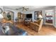 Living room featuring hardwood floors, comfortable leather seating, decorative fireplace and large windows at 30475 Satinleaf Run, Brooksville, FL 34602