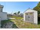 A backyard view showcasing a storage shed, wooden fence, and ample green space at 3207 Coldwell Dr, Holiday, FL 34691