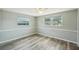 Sunlit bedroom with neutral paint, wood-look floors, base molding and a ceiling fan at 3207 Coldwell Dr, Holiday, FL 34691