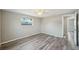 Bright bedroom featuring neutral walls, wood-look floors, and bright window at 3207 Coldwell Dr, Holiday, FL 34691