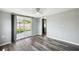 Bedroom with sliding glass doors to the backyard, wood-look floors, and neutral walls at 3207 Coldwell Dr, Holiday, FL 34691
