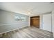Bright bedroom with wood-look flooring, ceiling fan, and closet with wood paneling at 3207 Coldwell Dr, Holiday, FL 34691