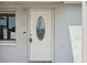 Close-up of the front door showing the glass detail, lock, and siding of the house at 3207 Coldwell Dr, Holiday, FL 34691