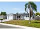 Charming single-story home featuring a brick and stucco facade, solar panels, and a well-manicured lawn at 3207 Coldwell Dr, Holiday, FL 34691