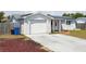 Charming single-story home featuring a brick and stucco facade, solar panels, and a well-manicured lawn at 3207 Coldwell Dr, Holiday, FL 34691