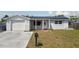 Charming single-story home featuring a brick and stucco facade, solar panels, and a well-manicured lawn at 3207 Coldwell Dr, Holiday, FL 34691