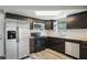 Kitchen with stainless steel appliances, dark cabinets, butcher block countertop, and white subway tile at 3207 Coldwell Dr, Holiday, FL 34691