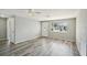 Bright living room with gray wood floors, a front window, and ceiling fan at 3207 Coldwell Dr, Holiday, FL 34691