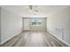 Bright living room with gray wood floors, a front window, and ceiling fan at 3207 Coldwell Dr, Holiday, FL 34691