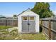 Close up of the backyard storage shed with windowed double doors and neutral gray and white colors at 3207 Coldwell Dr, Holiday, FL 34691