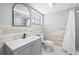 Bathroom featuring modern vanity, decorative mirror, and tiled shower with updated finishes at 3543 Rockaway Dr, Holiday, FL 34691