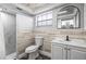 This is a bathroom featuring a tiled shower, a vanity with white cabinets, and a decorative wood plank accent wall at 3543 Rockaway Dr, Holiday, FL 34691