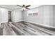 Bright bedroom with hardwood floors, ceiling fan and a window view with walk-in closet and open doorway at 3543 Rockaway Dr, Holiday, FL 34691