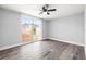 Bedroom with wood-look flooring, ceiling fan, and large windows for natural light at 3543 Rockaway Dr, Holiday, FL 34691