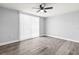 Spacious bedroom featuring wood-look floors, neutral walls, a ceiling fan, and a large window at 3543 Rockaway Dr, Holiday, FL 34691
