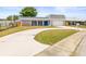 This home has a two-car garage and a charming blue front door at 3543 Rockaway Dr, Holiday, FL 34691
